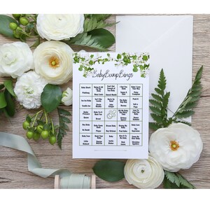 May include: A printable baby shower bingo card with a floral design. The card has a green and white floral border and the text "Baby Bump Bings" at the top. The bingo card has 25 squares with different phrases related to pregnancy and babies.