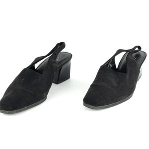 May include: A pair of black suede heeled slingback shoes with a low block heel.