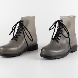 May include: A pair of clear rubber lace-up boots with black laces.