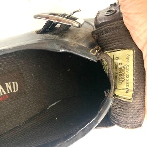 May include: A dark brown leather shoe with a silver-toned metal buckle strap. The interior features a black textured insole with the brand name Eastland. A yellow tag inside displays the text Style 3139-02 SIZE 6M OPEN ROAD EastlandShoe.com.