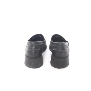 May include: A pair of black leather loafers with a chunky rubber sole.