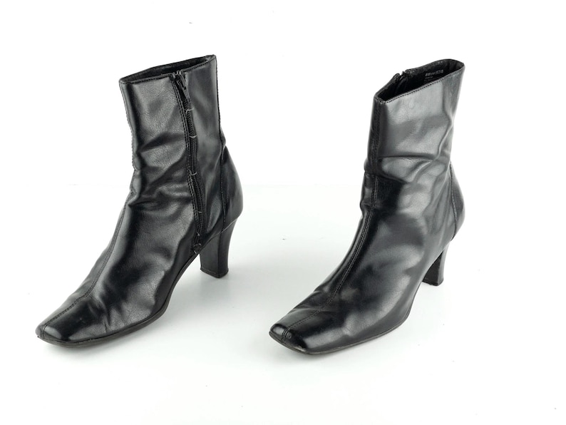 May include: A pair of black leather ankle boots with a square toe and a low block heel.
