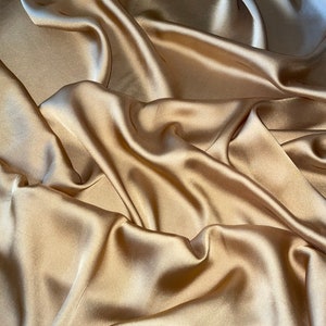 Tessuto di raso charmeuse leggero color oro scuro, 1 metro di larghezza.