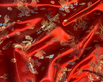 Könnte beinhalten: Roter Satinstoff mit einem goldenen und blauen gestickten Drachen- und Phönixmuster.