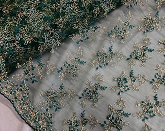 May include: Green and gold embroidered fabric with a floral pattern. The fabric is sheer and has a delicate texture.