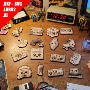 May include: A collection of laser-cut wooden shapes featuring retro 1980s and 1990s technology icons, including a boombox, floppy disk, cassette tape, joystick, slinky, digital watch, roller skate, synthesizer, arcade cabinet, and handheld phone.
