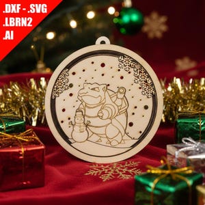May include: A wooden Christmas ornament featuring a laser-cut design of a cartoon character with a snowman in a snowy scene. The ornament has a circular shape with a small loop for hanging. The background includes Christmas presents and a Christmas tree.