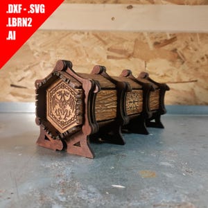 May include: Wooden decorative boxes with intricate laser-cut designs. The boxes are stained in shades of brown and feature detailed carvings of a dragon, compass, and other symbols. The boxes are displayed on a metallic surface.