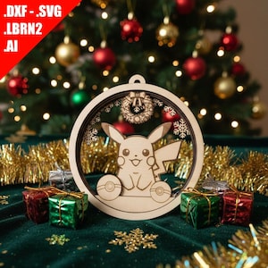 May include: A wooden Christmas ornament featuring Pikachu, snowflakes, and a wreath design. The ornament is laser-cut and has a circular shape. The background includes a Christmas tree, wrapped gifts, and gold tinsel.