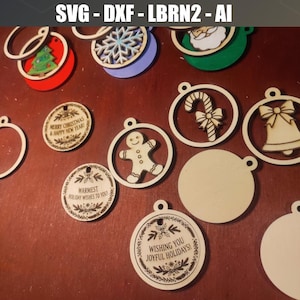 May include: A collection of circular wooden Christmas ornaments featuring laser-cut designs including a gingerbread man, candy cane, bell, snowflake, and tree. Several ornaments display engraved holiday greetings like Merry Christmas and Happy New Year.