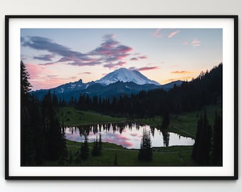 May include: A framed photograph of a mountain lake reflecting a pink and purple sunset sky. The mountain in the background is snow-capped and the lake is surrounded by trees.