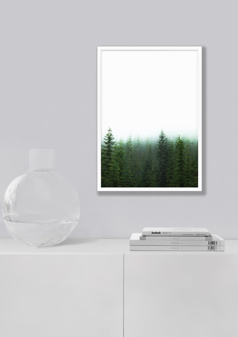May include: A framed print of a misty forest with tall evergreen trees. The trees are green and the background is a soft white.