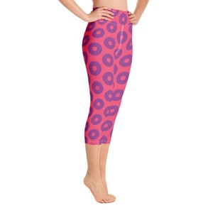May include: Pink and purple patterned yoga capris. The leggings have a high waist and a cropped length.