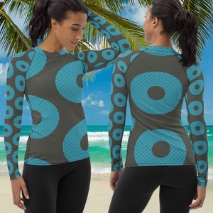 May include: A long-sleeved shirt with a geometric pattern of blue circles on a gray background. The shirt is shown on a model in front of a beach scene.