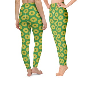 May include: Green leggings with a yellow donut pattern. The leggings are form-fitting and have a high waist.