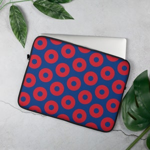 May include: A blue laptop sleeve with a red donut pattern. The sleeve has a zipper closure.