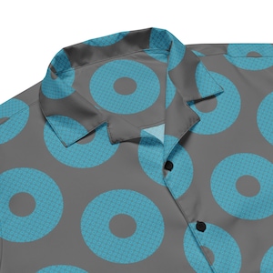 May include: A gray button-up shirt with a repeating pattern of large, light blue circles. Each circle has a gray center and is filled with a smaller, dotted pattern. The shirt collar and buttons are visible.