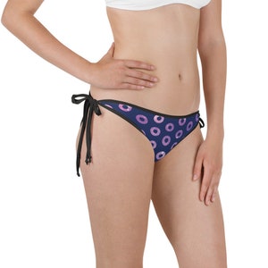 Op de afbeelding: Donkerblauwe bikini onderkant met een roze en wit donut patroon. De bikini onderkant heeft zwarte banden aan elke kant.