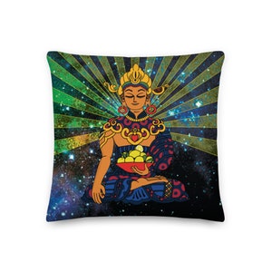 May include: A colorful pillow featuring a stylized illustration of a Buddha figure sitting in meditation with a bowl of fruit in their lap. The background is a dark blue with green and yellow rays emanating from the Buddha, creating a cosmic effect.