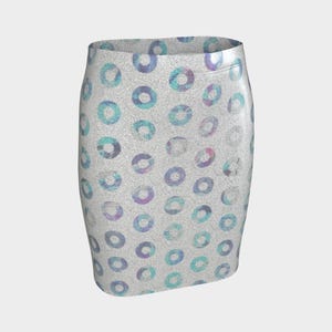 May include: A pencil skirt with a repeating pattern of colorful circles. The circles are in shades of blue, teal, and purple, set against a speckled, light gray background. The skirt is a bodycon style, fitted to the body.