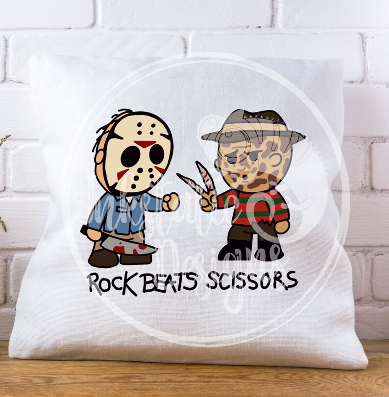 May include: White throw pillow with a cartoon graphic of two horror movie characters, Jason Voorhees and Freddy Krueger, facing each other. Jason holds a bloody machete, and Freddy holds scissors. The text "ROCK BEATS SCISSORS" is printed below.