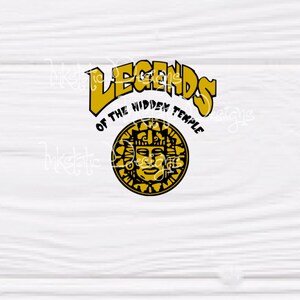 May include: A graphic design featuring the text "LEGENDS of the HIDDEN TEMPLE" in gold, arched over a circular emblem. The emblem is a black and gold sun-like face with intricate details, set against a white background.