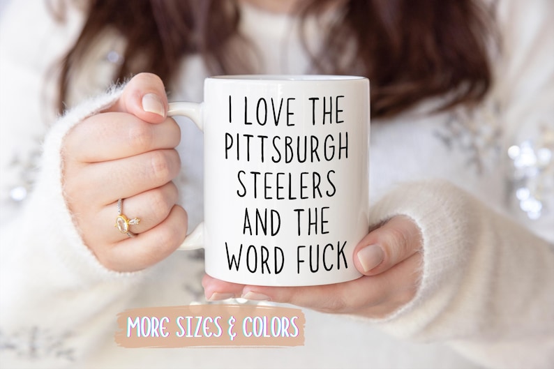 White ceramic mug with the text "I LOVE THE PITTSBURGH STEELERS AND THE WORD FUCK" in black.