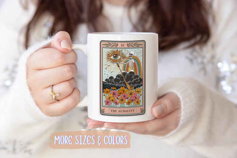 White ceramic mug featuring a tarot card design with a skeleton, eye, and rainbow. The card reads "THE AUDACITY" in a decorative frame with floral accents. Gift for him. Gift for her. Birthday gift. Christmas present. 11oz and 15oz, several colors. Unique custom made coffee mug. Best friend mugs. Coffee lover. Secret santa. Coworker gift exchange. Stocking stuffer. White elephant. Novelty cup Dishwasher safe & microwave safe