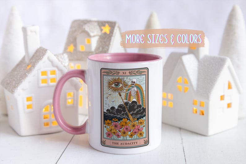 White ceramic mug with a pink interior and handle, featuring a tarot card design. The card depicts a skeleton, rainbow, and eye, with the text "THE AUDACITY". Gift for him. Gift for her. Birthday gift. Christmas present. 11oz and 15oz, several colors. Unique custom made coffee mug. Best friend mugs. Coffee lover. Secret santa. Coworker gift exchange. Stocking stuffer. White elephant. Novelty cup Dishwasher safe & microwave safe
