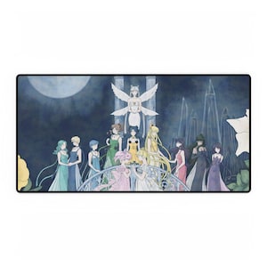 May include: A rectangular mousepad featuring a fantasy illustration. The artwork depicts a group of anime characters in colorful dresses standing on a bridge, with a large moon and architectural elements in the background. The color palette includes blues, greens, and yellows.