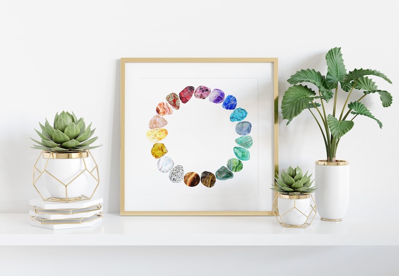 May include: A framed print of a watercolor painting of a circle of colorful gemstones. The print is displayed on a white shelf with two potted plants.