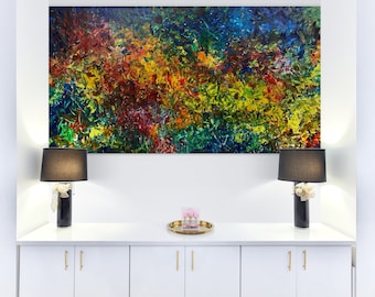 May include: A white cabinet with gold handles, two black lamps with white lampshades, and a colorful abstract painting hanging on the wall above the cabinet.