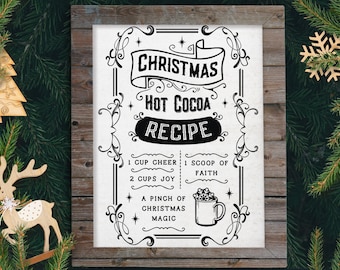 May include: Black and white printable sign with a vintage design that reads "Christmas Hot Cocoa Recipe". The recipe includes 1 cup cheer, 1 scoop of faith, 2 cups joy, and a pinch of Christmas magic.