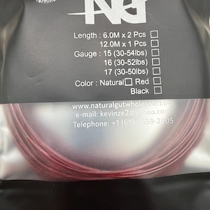 May include: A coil of red tennis string packaged in a black plastic pouch. The label features the text V5 The Terminator, NG, Length: 6.0M x 2 Pcs, 12.0M x 1 Pcs, Gauge: 15 (30-54lbs), 16 (30-52lbs), 17 (30-50lbs), Color: Natural, Red, Black.