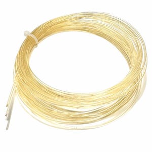 Pode incluir: Uma bobina de fio de cor dourada. O fio está enrolado em círculo e tem um diâmetro de aproximadamente 6 mm.