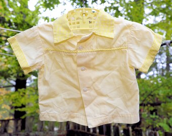 May include: A yellow short-sleeved button-up shirt with a gingham collar and cuffs.