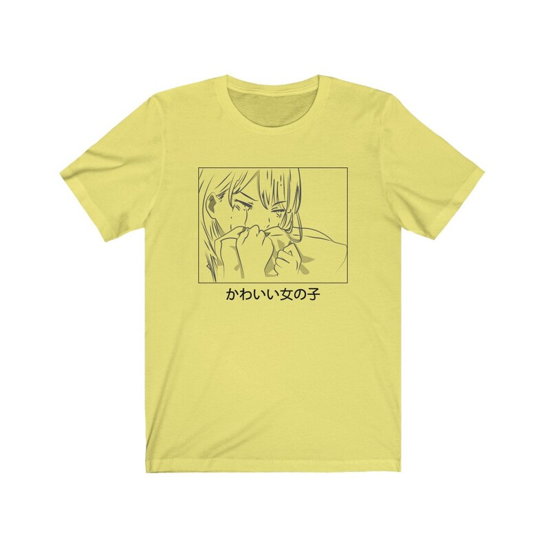 Może przedstawiać: Ż&oacute;łta koszulka z czarno-białym rysunkiem postaci anime, kt&oacute;ra płacze. Pod rysunkiem znajduje się napis "かわいい女の子".