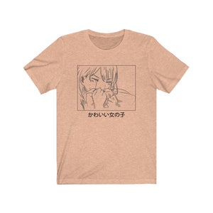 Może przedstawiać: Jasnobrązowy t-shirt z czarno-białym rysunkiem postaci anime z tekstem "かわいい女の子", co w języku polskim oznacza "słodka dziewczyna".