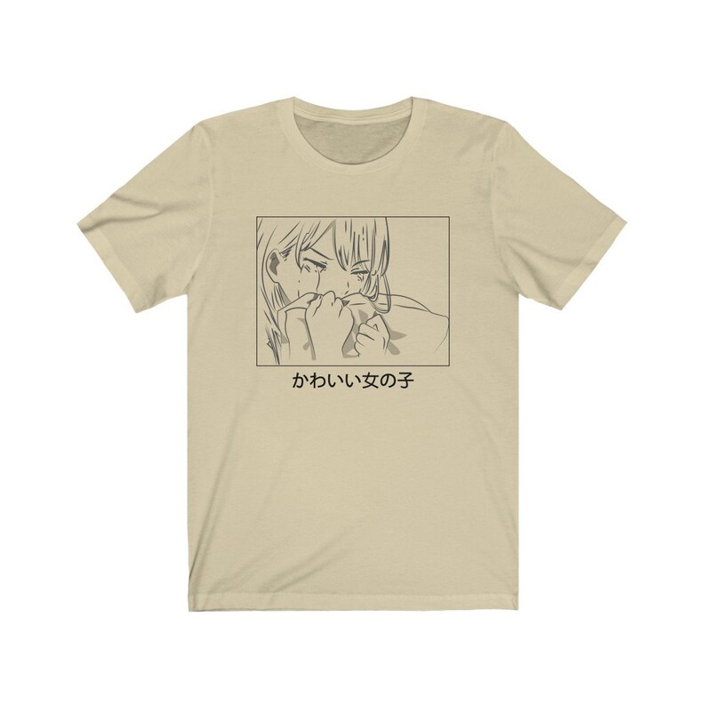 Może przedstawiać: Beżowa koszulka z czarno-białym rysunkiem postaci anime, kt&oacute;ra płacze. Pod rysunkiem znajduje się napis "かわいい女の子".