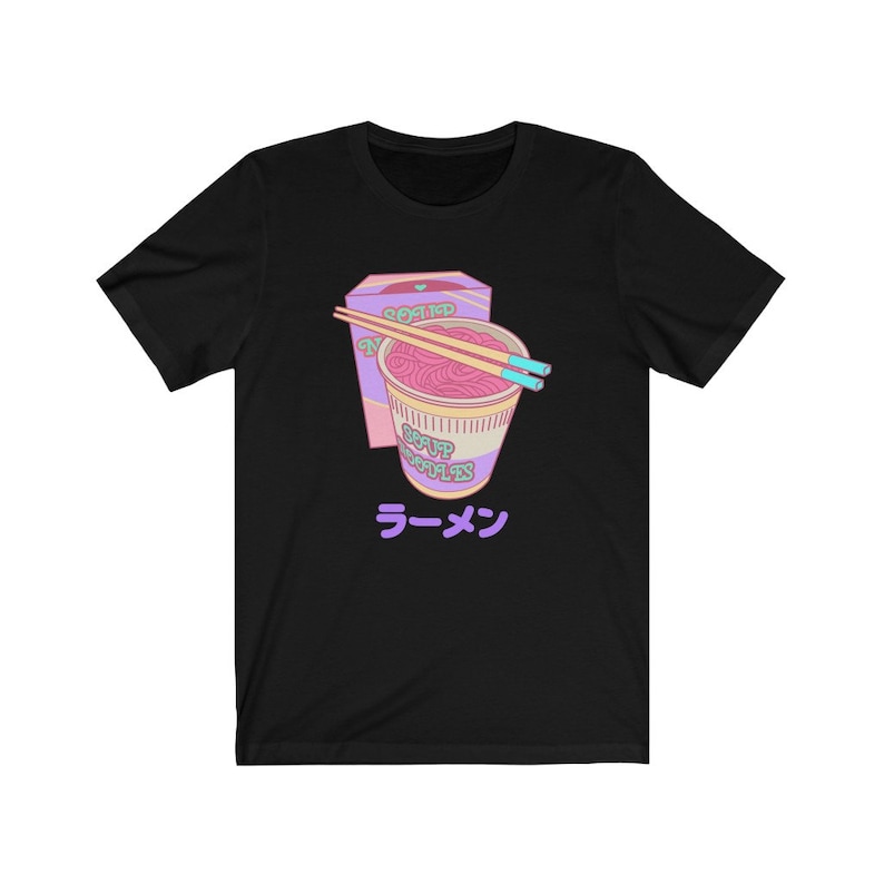 May include: Black t-shirt with a graphic of a pink and purple instant ramen cup with chopsticks and the text "SOUP NOODLES" and "ラーメン" in Japanese.