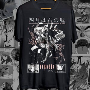 May include: Black t-shirt with a manga-style illustration, featuring characters and Japanese text. The design includes the English text "Your Lie in April" and the words "Thank you". The artwork is in black, white, and pink.