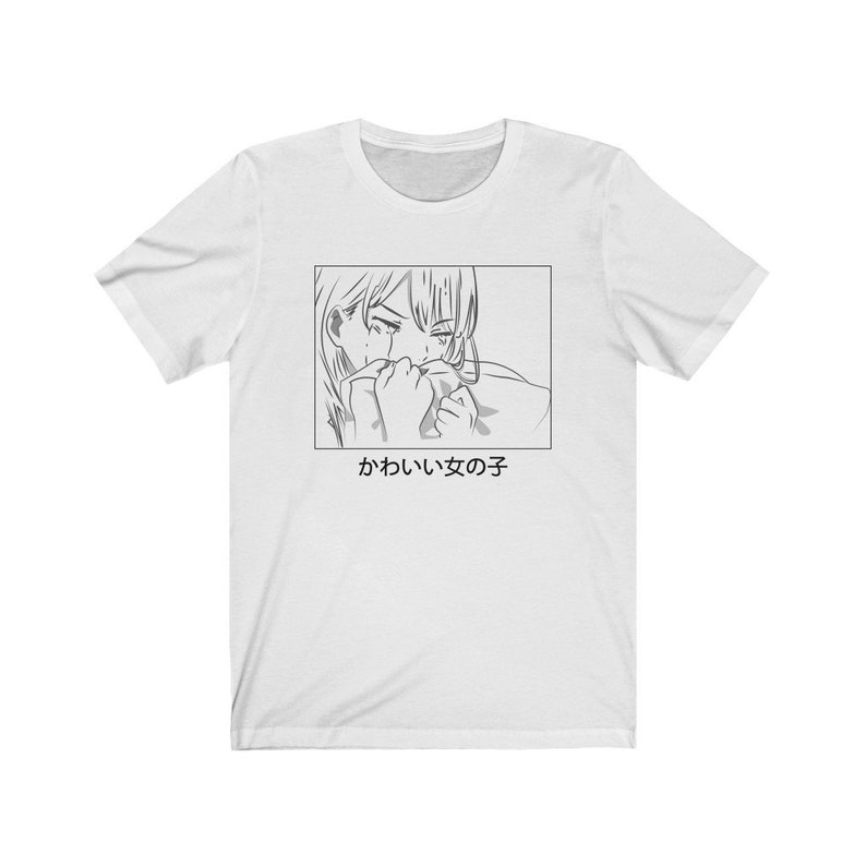Może przedstawiać: Biały t-shirt z czarno-białym rysunkiem postaci anime, kt&oacute;ra płacze. Pod rysunkiem znajduje się napis "かわいい女の子".