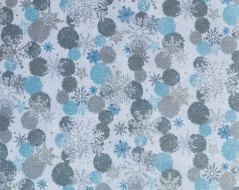 May include: White fabric with a repeating pattern of blue and gray snowflakes and circles. The snowflakes are stylized and the circles are slightly blurred.
