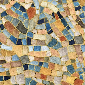 May include: Abstract mosaic pattern in a variety of colors including blue, brown, and yellow. The design features irregular shapes separated by gold lines with small black dots, creating a textured appearance. The overall effect is reminiscent of a stained-glass window.