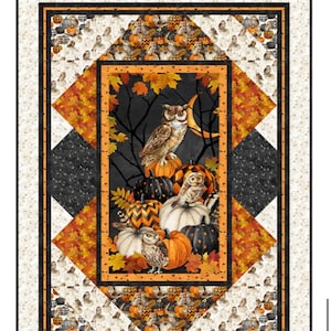 May include: A rectangular quilt featuring a central panel with owls perched on pumpkins against a dark background with autumn leaves and a crescent moon. The quilt is framed by geometric borders in orange, black, and cream with owl and pumpkin patterns.
