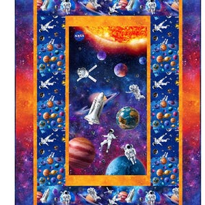 May include: A colorful quilt featuring a space theme. The design includes planets, astronauts, a shuttle, and the sun, set against a starry background. The NASA logo is visible. The quilt has a vibrant orange, blue, and purple color scheme.