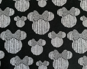 May include: Black fabric with a white repeating pattern of stylized Mickey Mouse heads.