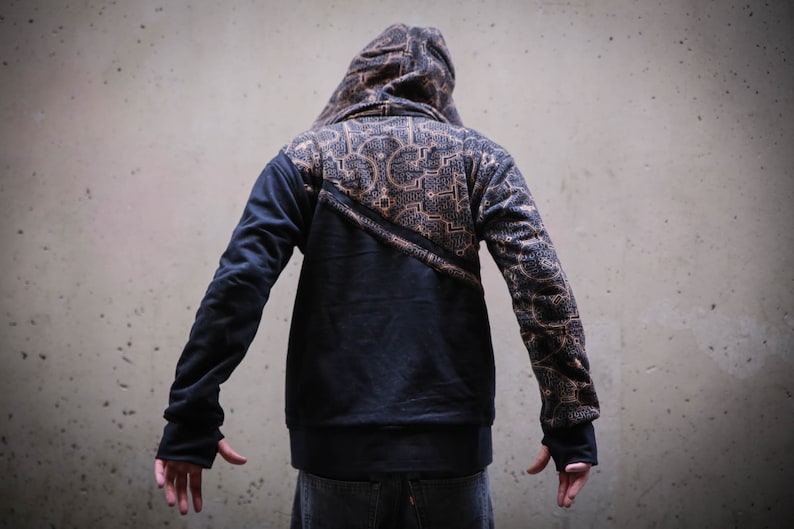 May include: A black hooded sweatshirt with a geometric pattern on the back and sleeves. The hoodie has a zipper closure and a drawstring hood.