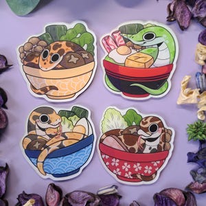 Könnte beinhalten: Vier farbenfrohe Aufkleber mit Cartoon-Schlangen in Ramen-Schalen. Jeder Aufkleber hat ein anderes Schlangendesign, wobei sich die Schlangen in Ramen-Schalen mit verschiedenen Belägen wie Pilzen, Eiern und Gemüse befinden. Die Schalen sind in verschiedenen Farben und Mustern.