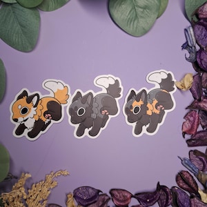Könnte beinhalten: Drei Aufkleber mit Cartoon-Füchsen in Laufpose. Die Füchse haben orangefarbenes, schwarzes und graues Fell mit weißen Akzenten. Die Aufkleber befinden sich auf einem lila Hintergrund mit dekorativen Elementen.